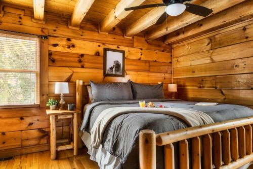 a bedroom with a bed in a log cabin at Family Haven by Dollywood - Hot Tub - Game Room in Pigeon Forge
