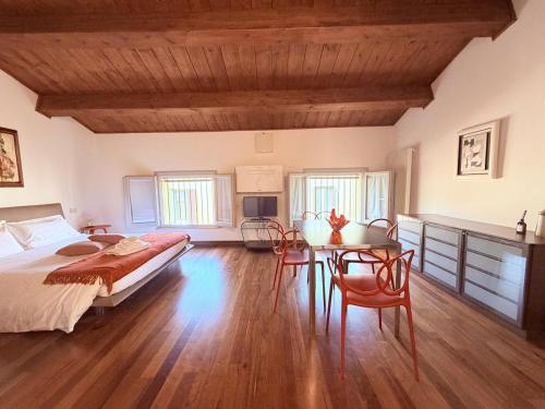 a bedroom with a bed and a table and chairs at Casa Petrucci 2 centro storico, accesso ztl e park gratuito in Forlì