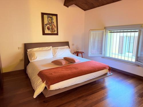 a bedroom with a large bed with a wooden floor at Casa Petrucci 2 centro storico, accesso ztl e park gratuito in Forlì