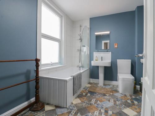 a bathroom with a tub and a toilet and a sink at Meregate Cottage in Margate
