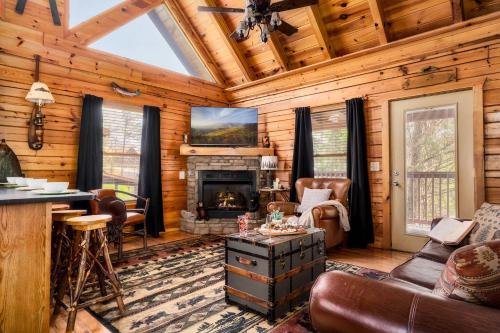 a living room with a fireplace in a log cabin at Quaint & Cozy - Great location - Hot Tub - BBQ in Pigeon Forge
