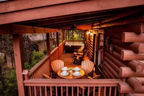 a table and chairs on a balcony of a cabin at Quaint & Cozy - Great location - Hot Tub - BBQ in Pigeon Forge