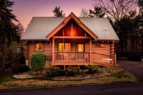 a log cabin with a porch and a metal roof at Quaint & Cozy - Great location - Hot Tub - BBQ in Pigeon Forge