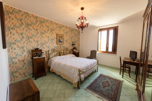 a bedroom with a bed and a table and a window at Locanda Severino in Caggiano