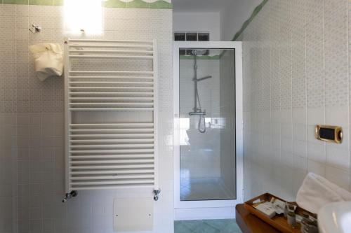 a shower with a glass door in a bathroom at Locanda Severino in Caggiano
