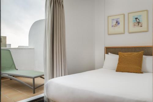 a hotel room with a bed and a chair at BYPILLOW Tiento in Cádiz
