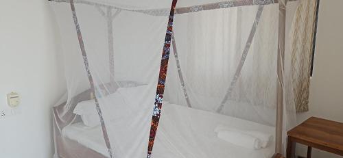 a bed with a canopy in a room at Upole HOTEL in Nungwi