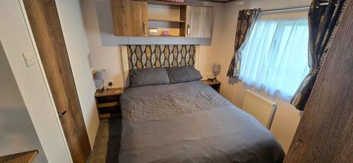 a small bedroom with a bed and a window at CJ's Happy Place in Heysham
