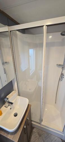 a white bathroom with a sink and a shower at CJ's Happy Place in Heysham