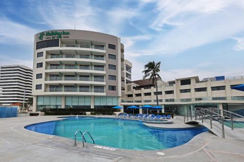 a hotel with a swimming pool in front of a building at Holiday Inn Veracruz-Boca Del Rio by IHG in Veracruz