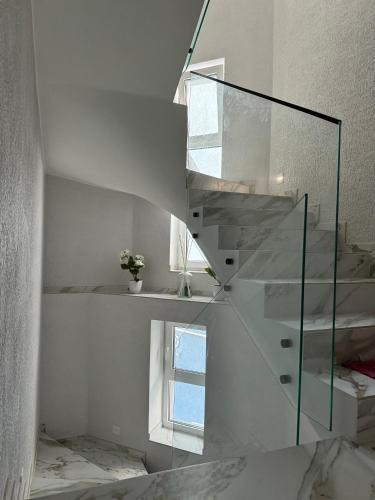 a glass staircase in a white room with a window at Urban Nest in Truskavets