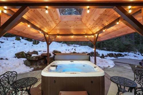a jacuzzi tub under a wooden roof with lights at Yosemite Spirit in Yosemite West
