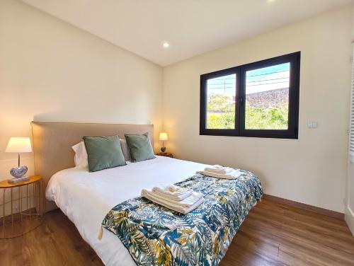 a bedroom with a bed and a window at O Nosso Refúgio in Água de Pau