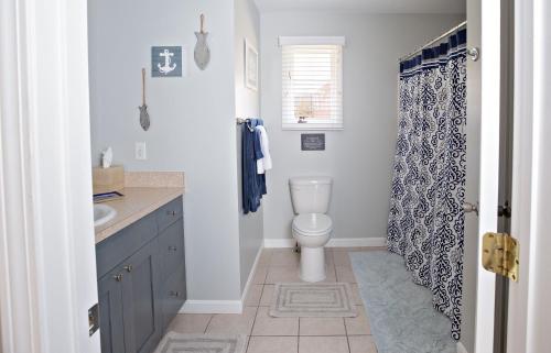 a bathroom with a toilet and a shower curtain at Exceptional Contemporary Retreat with 4 King Beds in Mystic CT in Groton