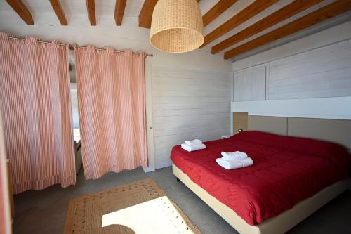 a bedroom with a red bed with towels on it at Ristorante Hotel DA VITTORIO in Menfi
