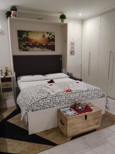 a bedroom with a large white bed with a wooden chest at La Calla al Colosseo in Rome