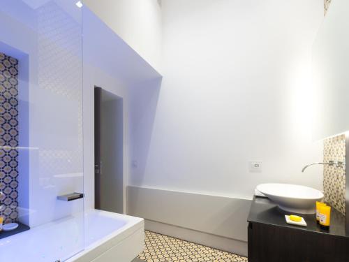 a bathroom with a white tub and a sink at Varò Apartment in Taormina