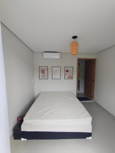 a bedroom with a bed in a white room at Enseada Beach in São Sebastião
