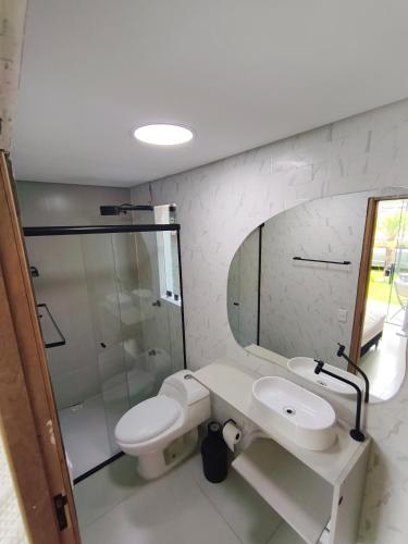 a bathroom with a sink and a toilet and a mirror at Enseada Beach in São Sebastião