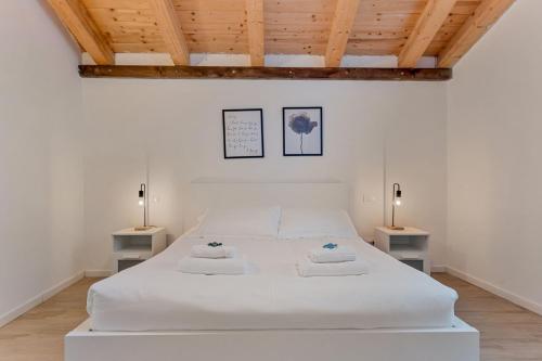 a bedroom with a large white bed with two lamps at Il Parco Apartment- Nature & Relax-Road To 5Terre in Beverino