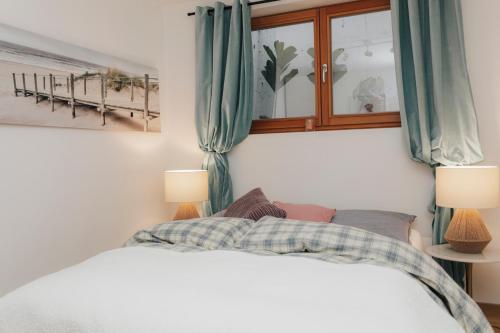 a bedroom with a white bed with blue curtains at Stilvoll und ruhig in Füssen