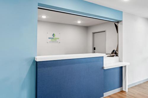 a room with a blue wall and a mirror at WoodSpring Suites Charlotte Northlake in Charlotte