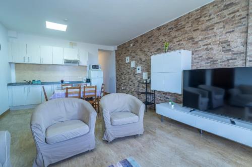 a living room with two chairs and a flat screen tv at Edificio Prieto VIV 2C in Puerto del Rosario