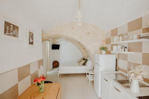 a kitchen with a table and a white refrigerator at Palazzo Pezzolla Apartments in Monopoli