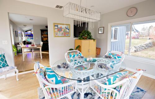 a dining room with a glass table and chairs at Exceptional Contemporary Retreat with 4 King Beds in Mystic CT in Groton
