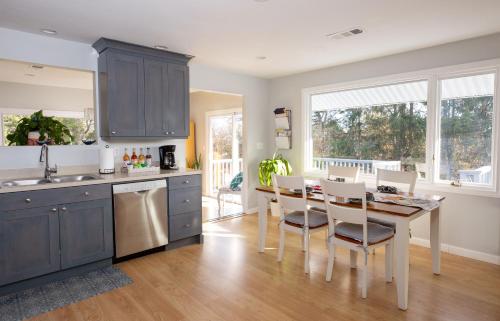 a kitchen with blue cabinets and a table and chairs at Exceptional Contemporary Retreat with 4 King Beds in Mystic CT in Groton