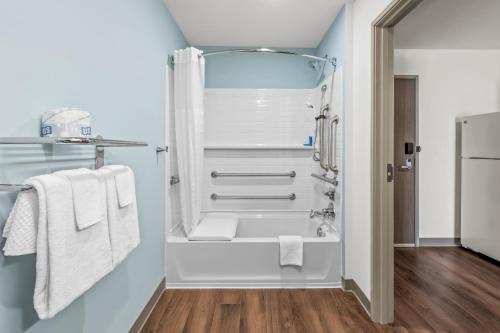 a bathroom with a shower and white towels at WoodSpring Suites Charlotte Northlake in Charlotte