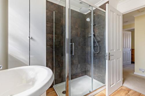a bathroom with a shower and a white tub and a sink at 3 Bed in Bodham oc-1sfc in Bodham