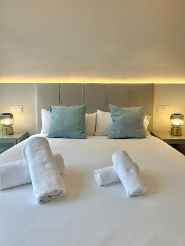 a large white bed with two towels on it at Madrid Modern Studio with Terrace & Parking in Madrid