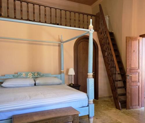 a bedroom with a bed and a staircase at Spiritu in Ḩārat al Qal‘ah
