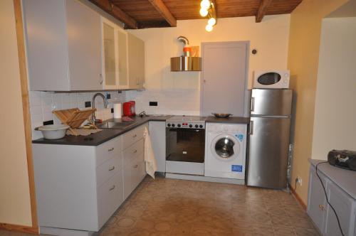 a kitchen with a refrigerator and a washing machine at Chez Gérard in Saint-Martin-Lars-en-Sainte-Hermine