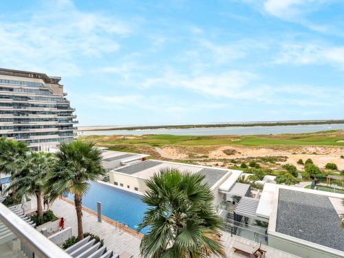 an aerial view of a resort with a pool and palm trees at Elite Nest - 2BR Apartment at Mayan with Private Beach Access in Abu Dhabi