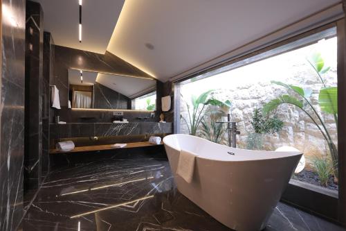 a bathroom with a tub and a large window at Heaven Prestige Hotel in Jounieh