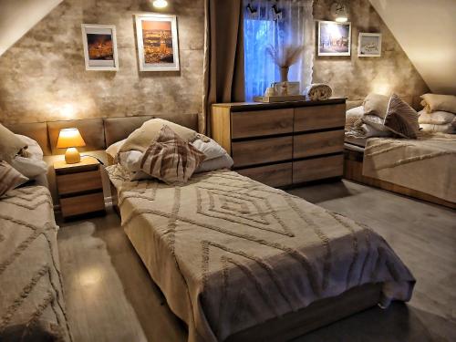 a bedroom with two beds and a dresser at Eleonor Accommodation exclusive house in Liszki