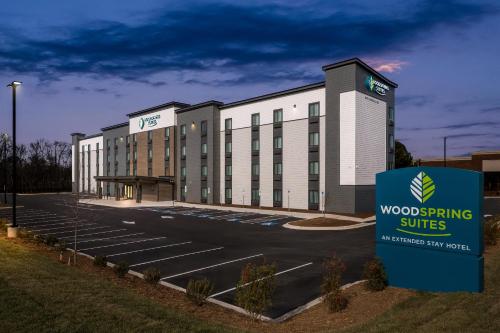 a hotel with a sign in front of a parking lot at WoodSpring Suites Charlotte Northlake in Charlotte