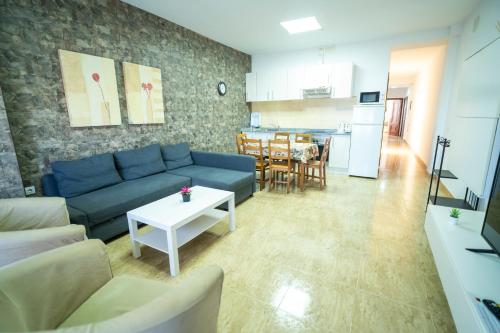 a living room with a blue couch and a table at Edificio Prieto VIV 2E in Puerto del Rosario