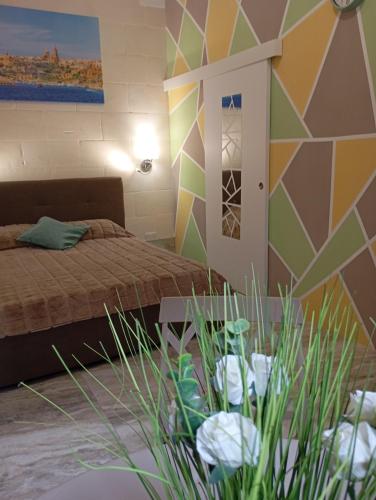 a bedroom with a bed and a colorful wall at NJ Stay Gozo in Għajnsielem