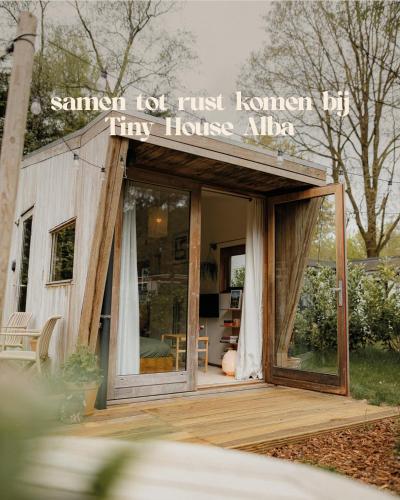 a tiny house with a sign that reads summer not just human try house alpha at Tiny House Alba - ervaar tiny house living in Diessen