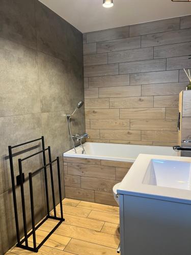 a bathroom with a tub and a toilet and a sink at Różana City Apartaments in Kutno