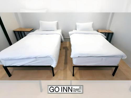 two beds sitting next to each other in a room at xx GO INN Phuket old Town in Ban Lo Long