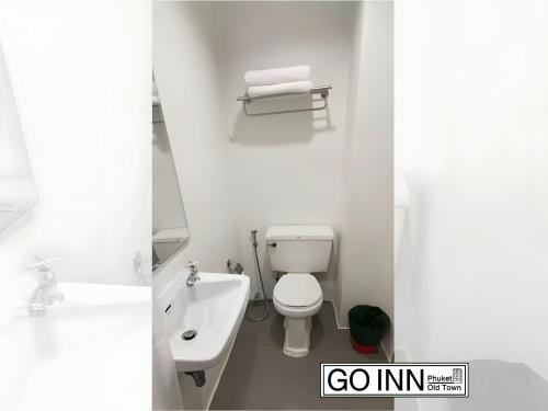 a white bathroom with a toilet and a sink at xx GO INN Phuket old Town in Ban Lo Long
