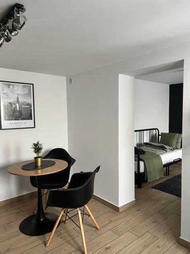 a room with a table and chairs and a bed at Różana City Apartaments in Kutno