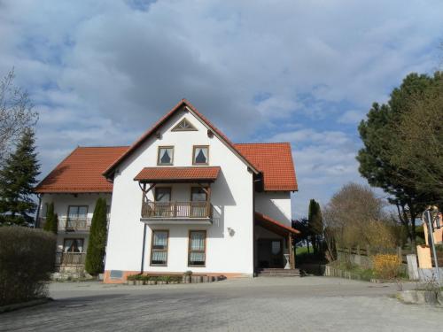 uma casa branca com um telhado vermelho em Landgasthof Asum em Dasing