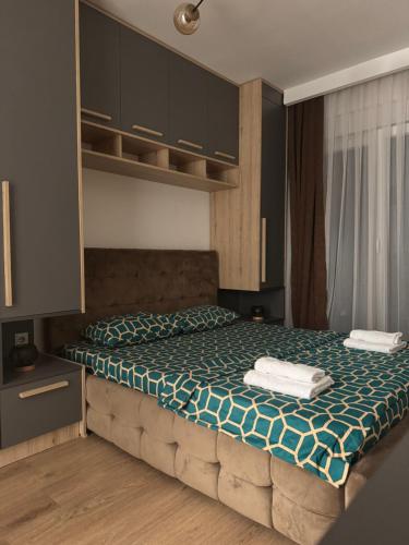 una camera da letto con un letto con due asciugamani sopra di DAF apartaments a Pristina