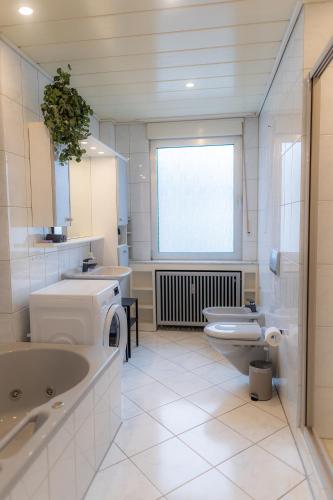 a bathroom with a sink and a toilet and a window at Kaiserviertel Gastromeile, City, Messe & Stadionnah in Dortmund