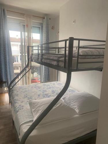 Appartement Terrasse في رويان: سريران بطابقين في غرفة بها نافذة